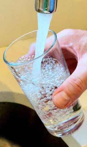 image of a glass being filled with water from a tap